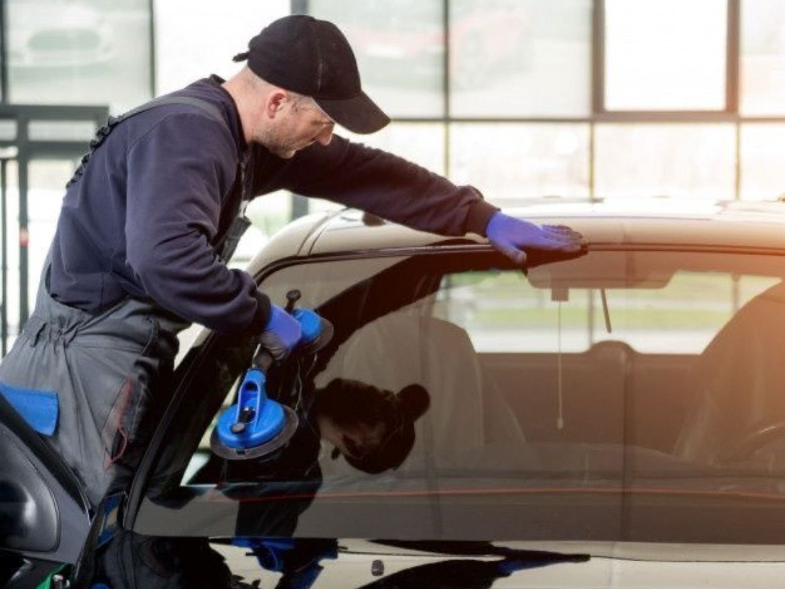 Technician applying tint film to car